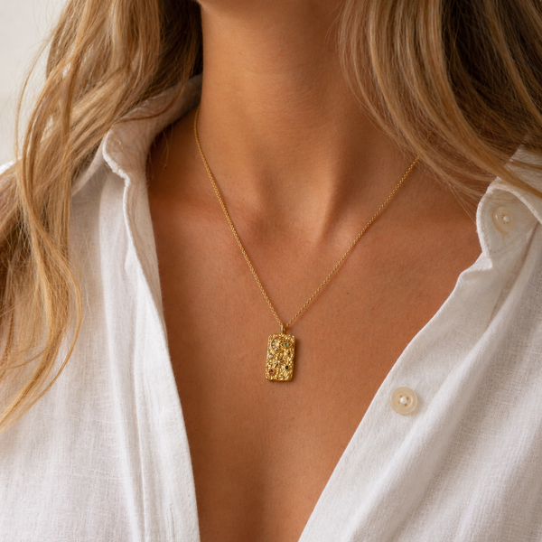 Gold PVD textured eye pendant necklace with coloured stone details on a fine chain.