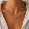 Chunky curb chain necklace with open heart pendant in gold and silver stainless steel on neutral background