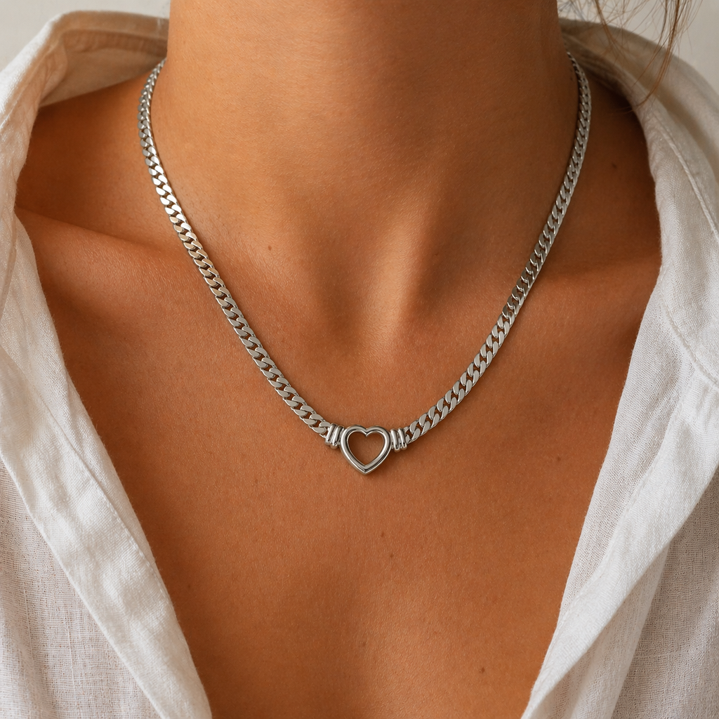 Chunky curb chain necklace with open heart pendant in gold and silver stainless steel on neutral background