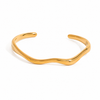 Gold and silver organic wave cuff bracelet on white background