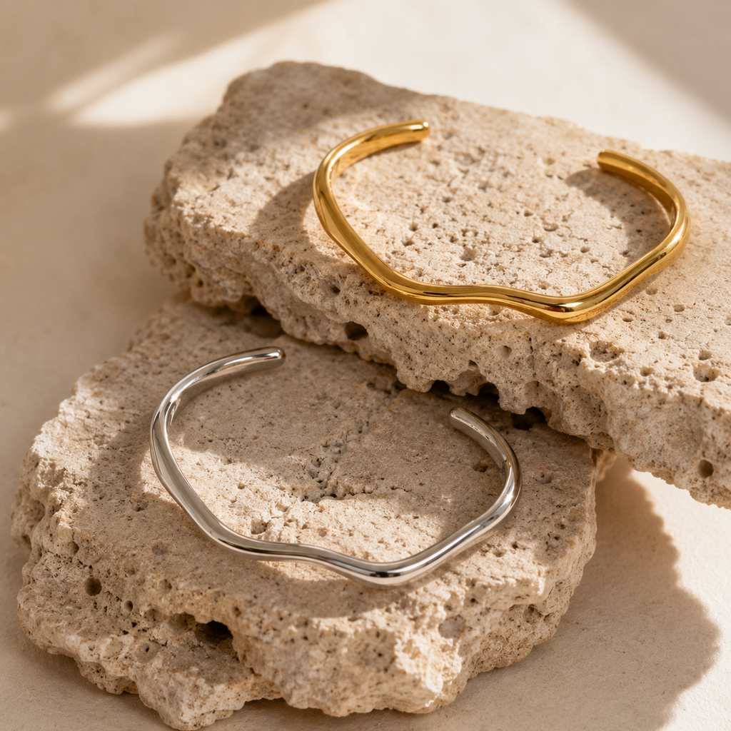 Gold and silver organic wave cuff bracelet on white background