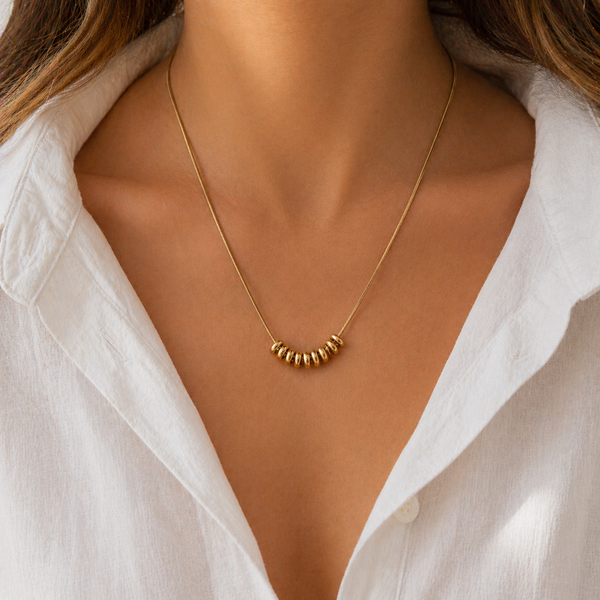 Drift Ring Necklace in gold PVD or stainless steel. Waterproof, ocean-proof, and designed for everyday wear. A minimal textured statement on a snake chain.