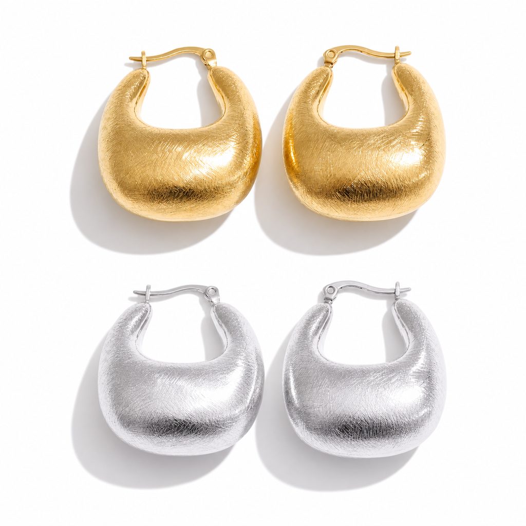 Gold and silver dome hoop earrings with a brushed texture and rounded sculptural shape, shown on a white background.