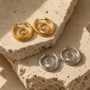 Gold and silver spiral hoop earrings with a sculptural halo design, 26.8mm diameter, on a clean white background.