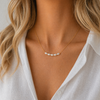 Lagoon pearl necklace with five organic pearls spaced along a fine stainless steel chain, available in gold and silver, worn at collarbone length.