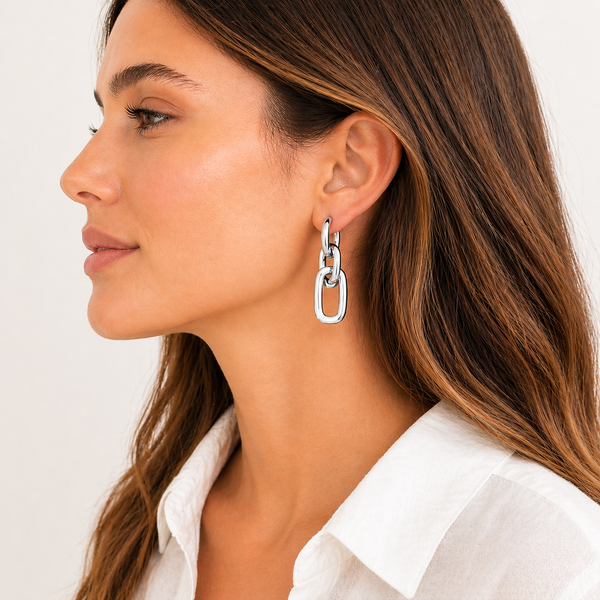 Gold and silver chain-link drop earrings with polished finish and huggie hoop closure on white background.