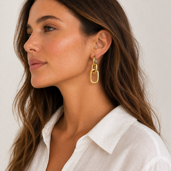 Gold and silver chain-link drop earrings with polished finish and huggie hoop closure on white background.