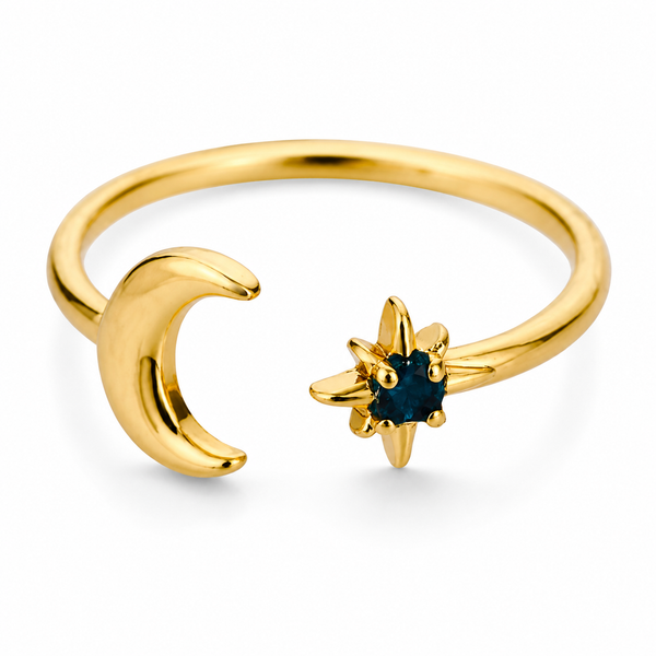 Gold and silver celestial moon and star adjustable ring with deep blue gemstone on white background.