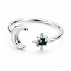 Gold and silver celestial moon and star adjustable ring with deep blue gemstone on white background.