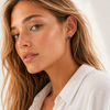 Gold and silver huggie earrings with black stone flower detail on a clean white background.