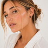 Gold and silver huggie earrings with black stone flower detail on a clean white background.