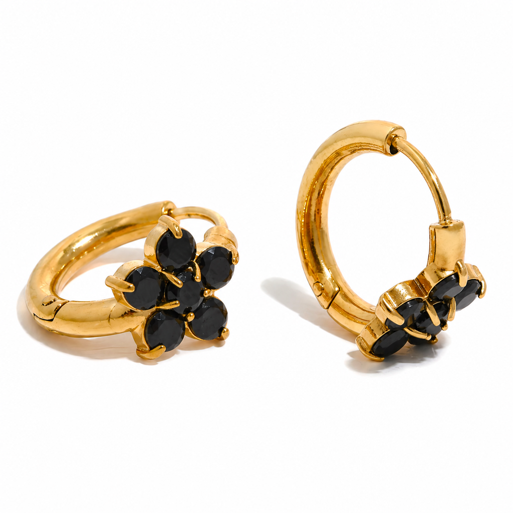 Gold and silver huggie earrings with black stone flower detail on a clean white background.