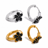 Gold and silver huggie earrings with black stone flower detail on a clean white background.