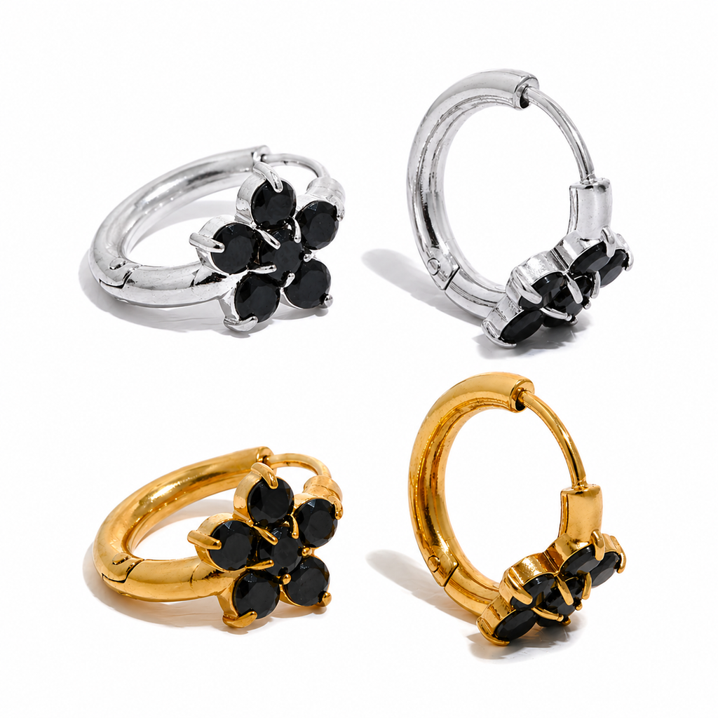 Gold and silver huggie earrings with black stone flower detail on a clean white background.