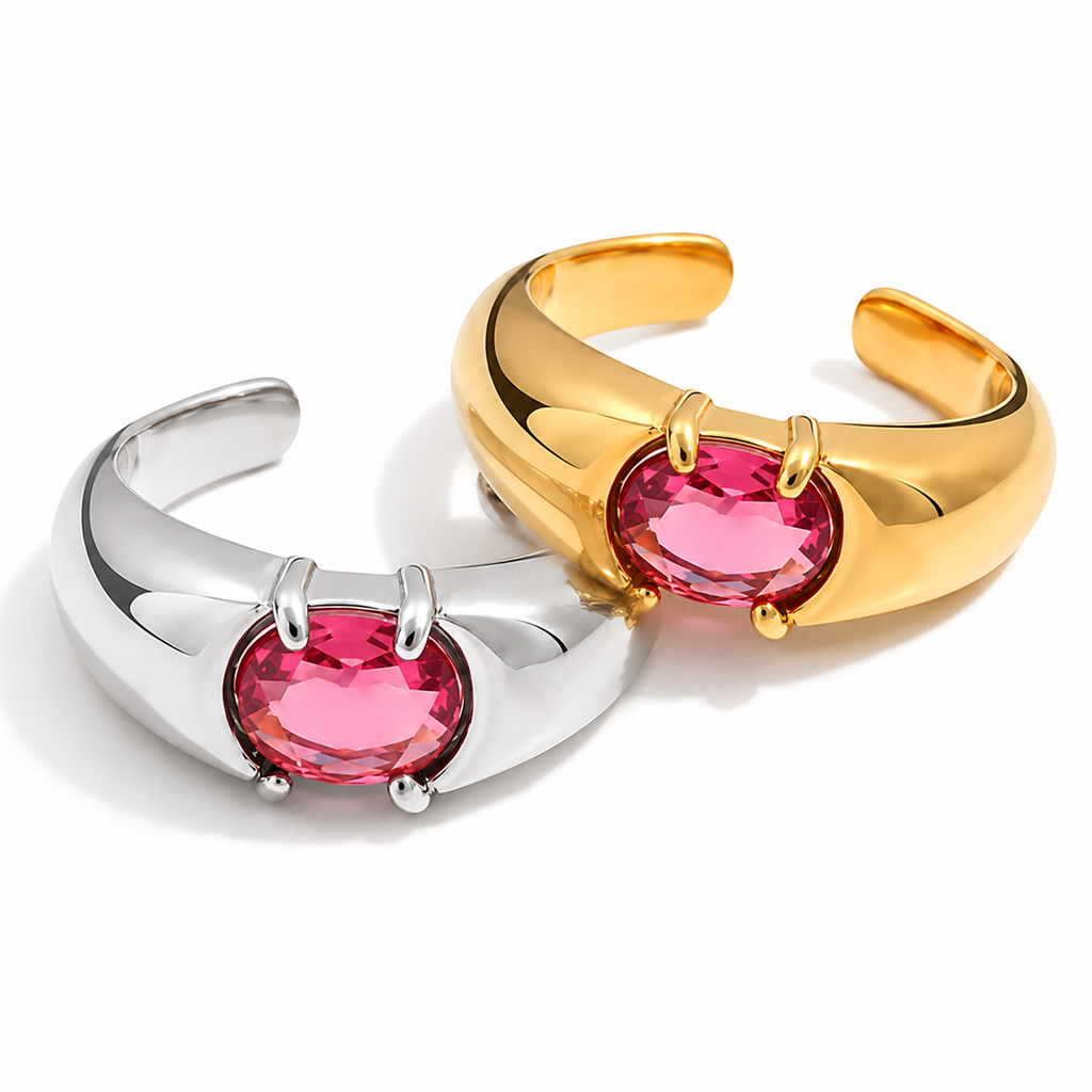 Gold and silver adjustable statement rings with oval pink crystal stones on a white background.