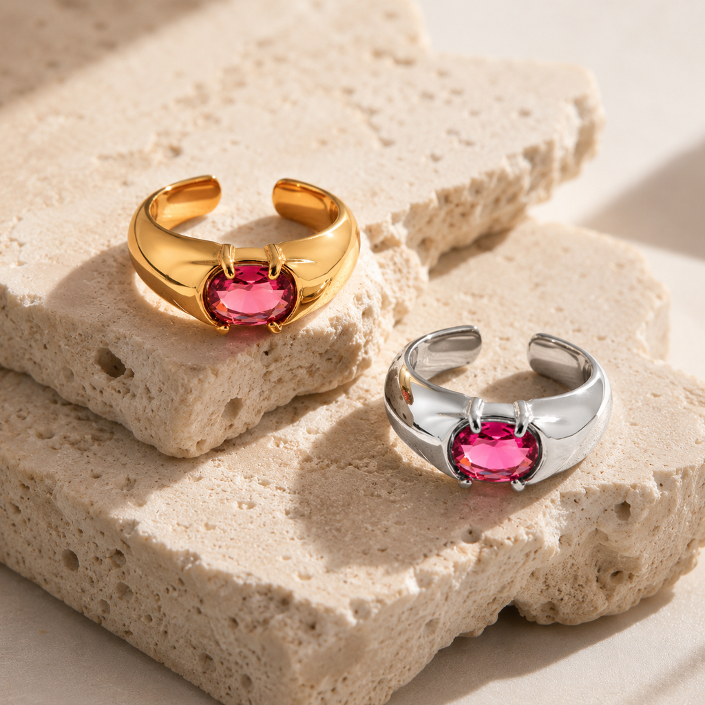 Gold and silver adjustable statement rings with oval pink crystal stones on a white background.