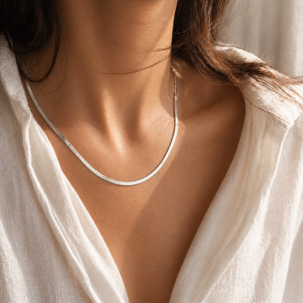 Gold flat 3mm chain necklace worn on neck with smooth reflective finish, minimal modern jewellery style