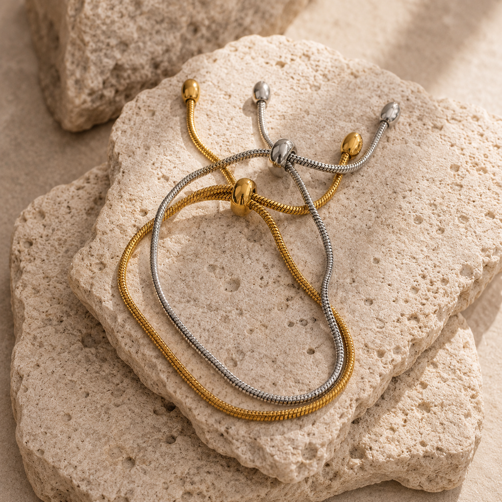 Adjustable snake chain bracelet with sliding clasp in gold and silver stainless steel on white background