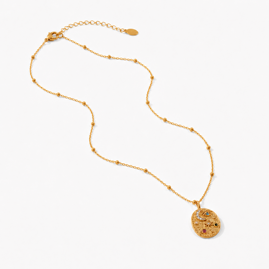 Gold celestial medallion pendant necklace featuring eye, moon and star detailing with coloured gemstones on a fine beaded chain.