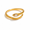Gold and silver adjustable open-band rings with marquise crystal detail displayed on raw travertine stone.
