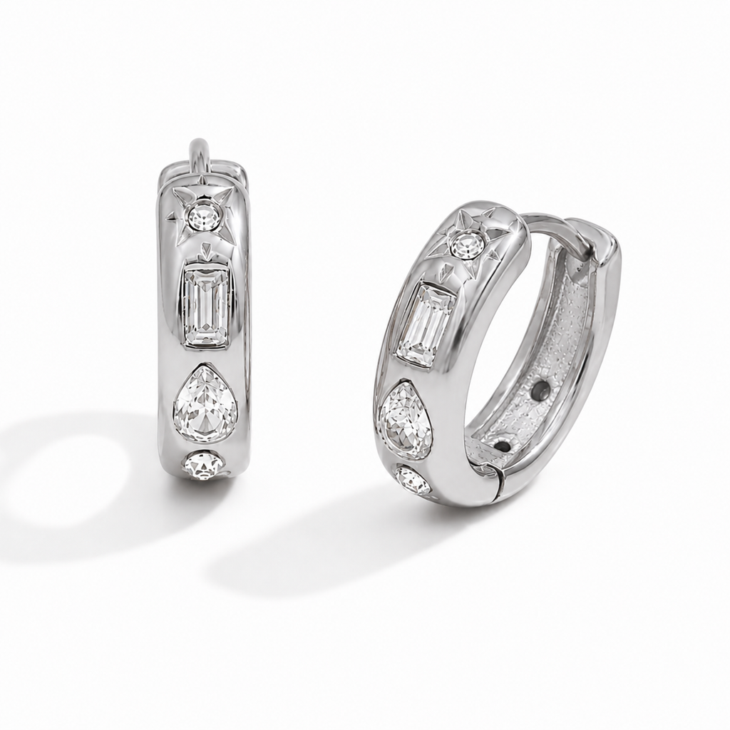 Gold and silver huggie earrings with clear cubic zirconia stones and a star detail on a polished finish.