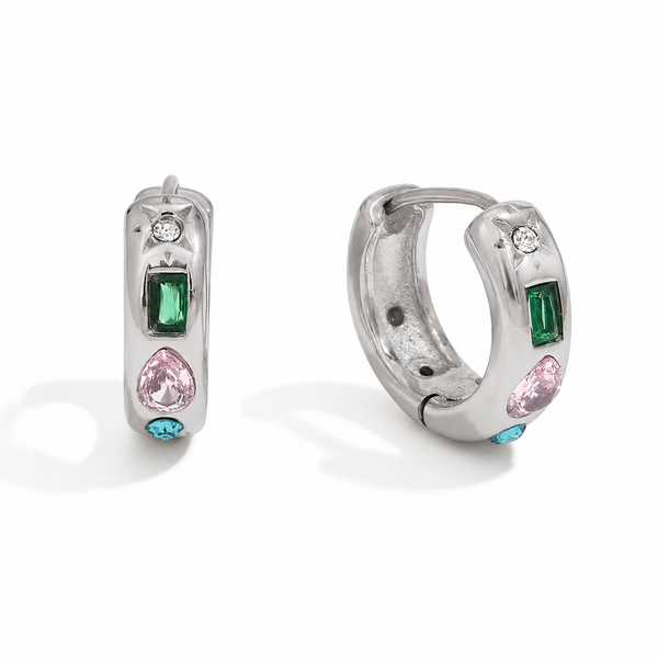 Gold and silver huggie earrings with colourful gemstone settings including green, pink, and blue stones with a star detail.