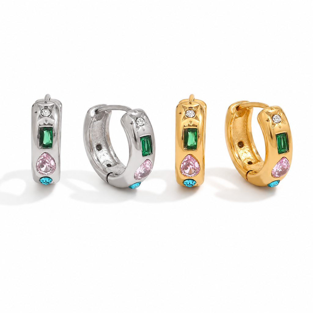 Gold and silver huggie earrings with colourful gemstone settings including green, pink, and blue stones with a star detail.