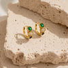 Gold huggie earrings with three stacked stones in green, clear and navy, textured bezel settings, minimal white background